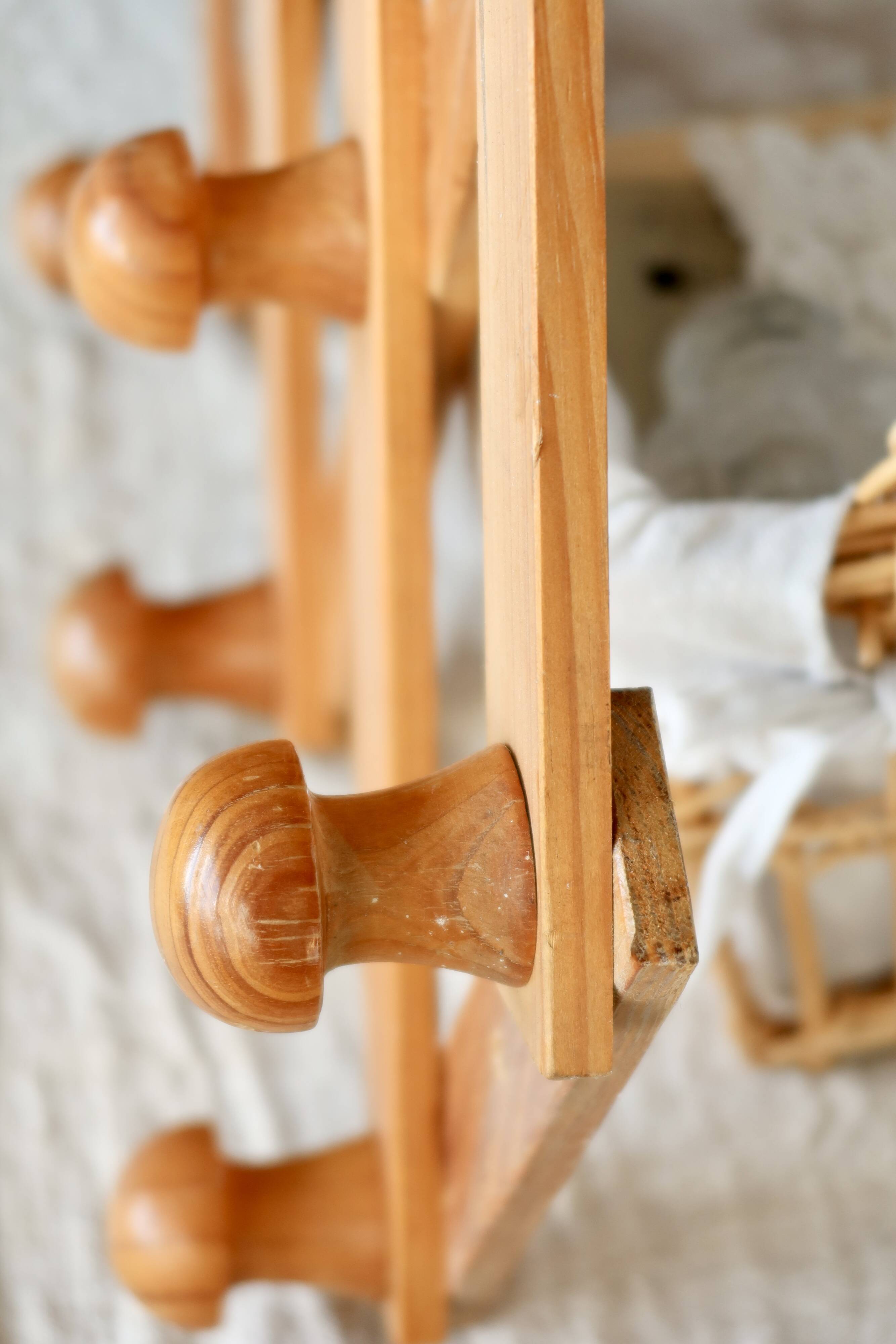 Antique wall-mounted coat rack accordion in dark pine, 10 wooden hooks.