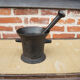 Ancient large mortar and pestle of a black cast iron apothecary.