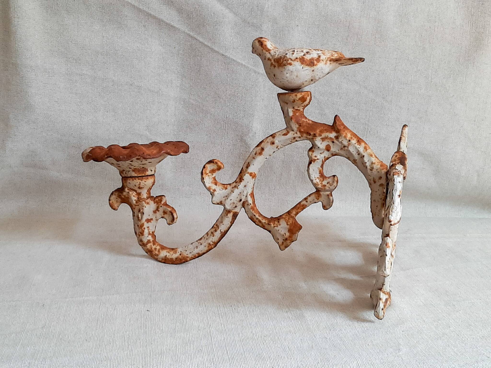 Wall lamp in antique cast iron with bird and scroll decorations.