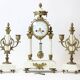 Clock and pair of Louis XVI style candelabras.