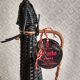 Glass bottle covered with black scoubidou with twisted golden handle - vintage