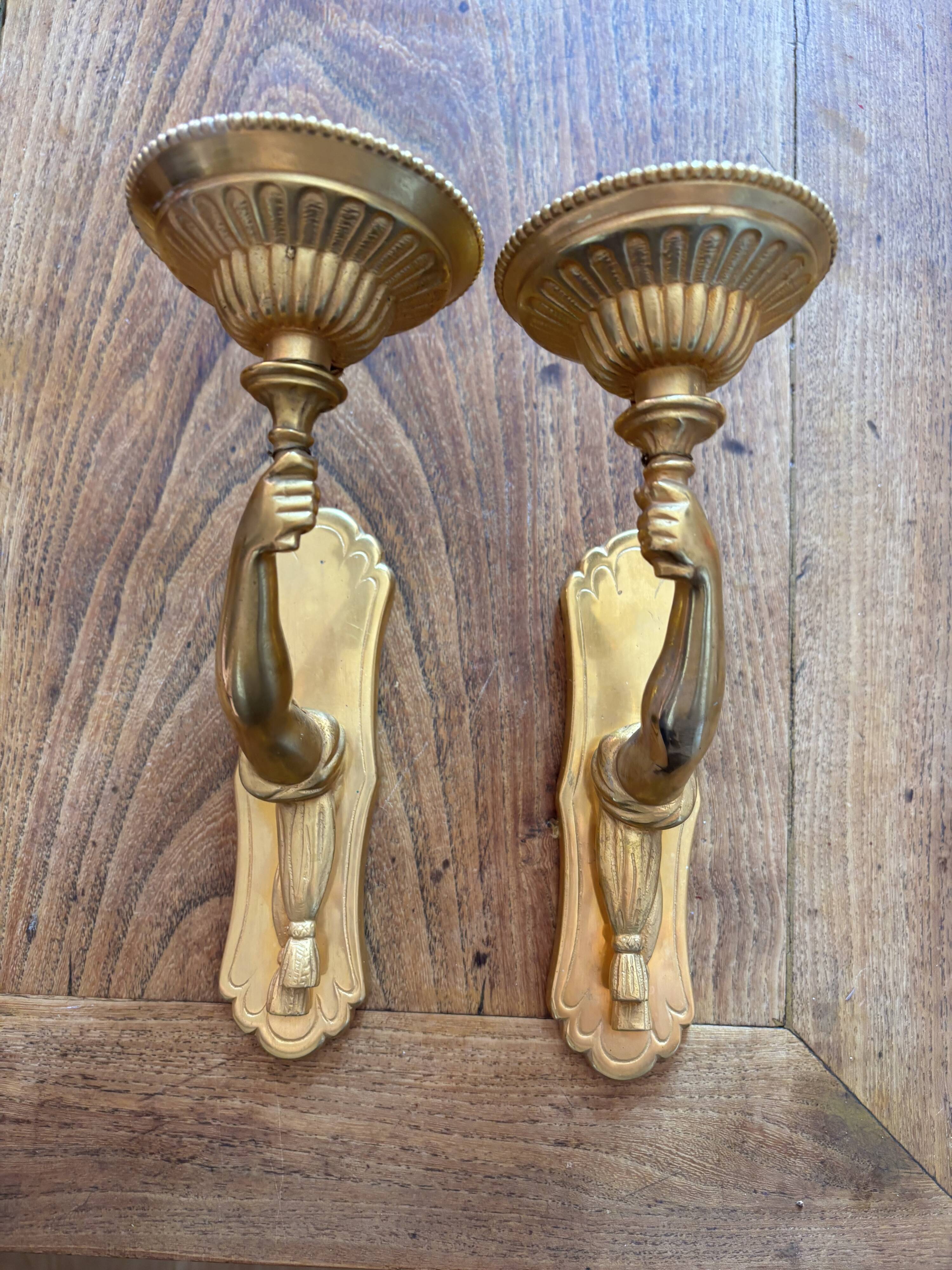 Pair of bronze wall sconces with outstretched arms and hands
