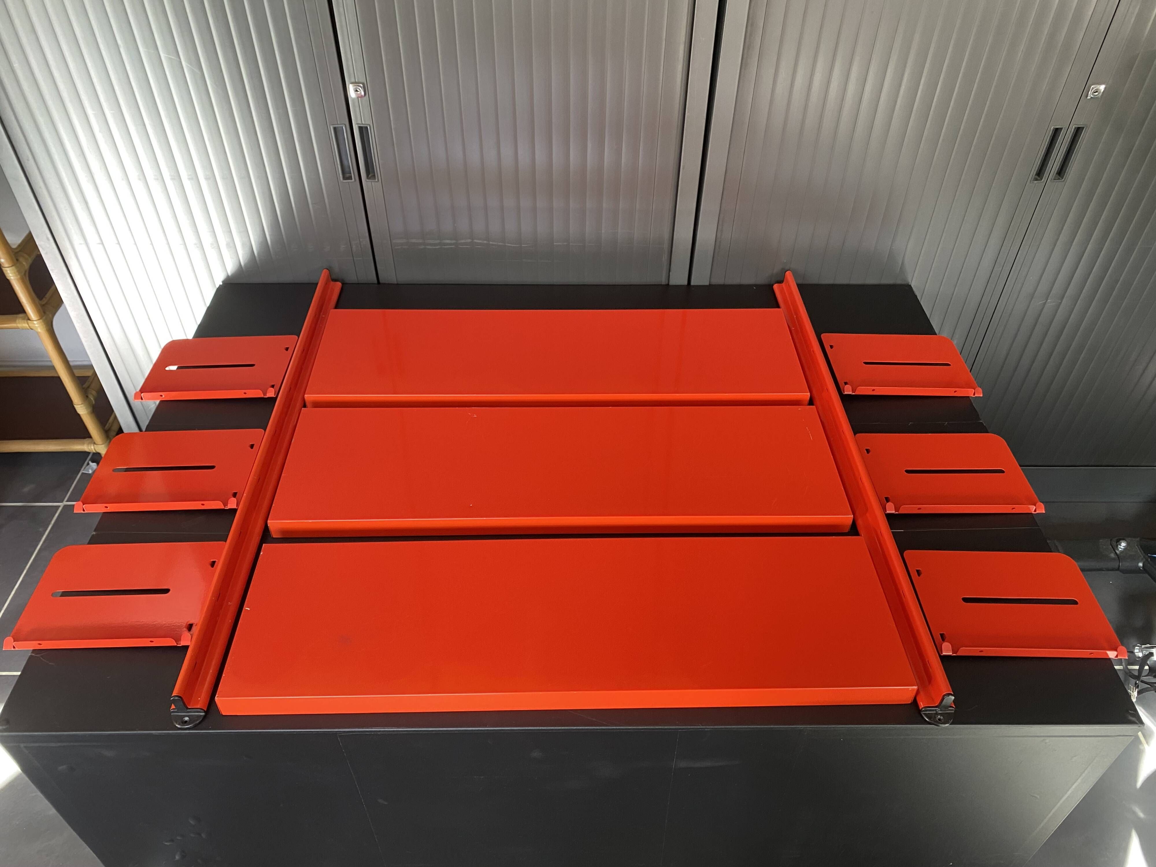 Modular red metal wall shelf in Congresso Lips Vago style.