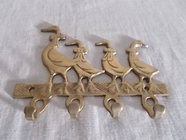 Wall-mounted tea towel holder or key holder in brass with ducks.