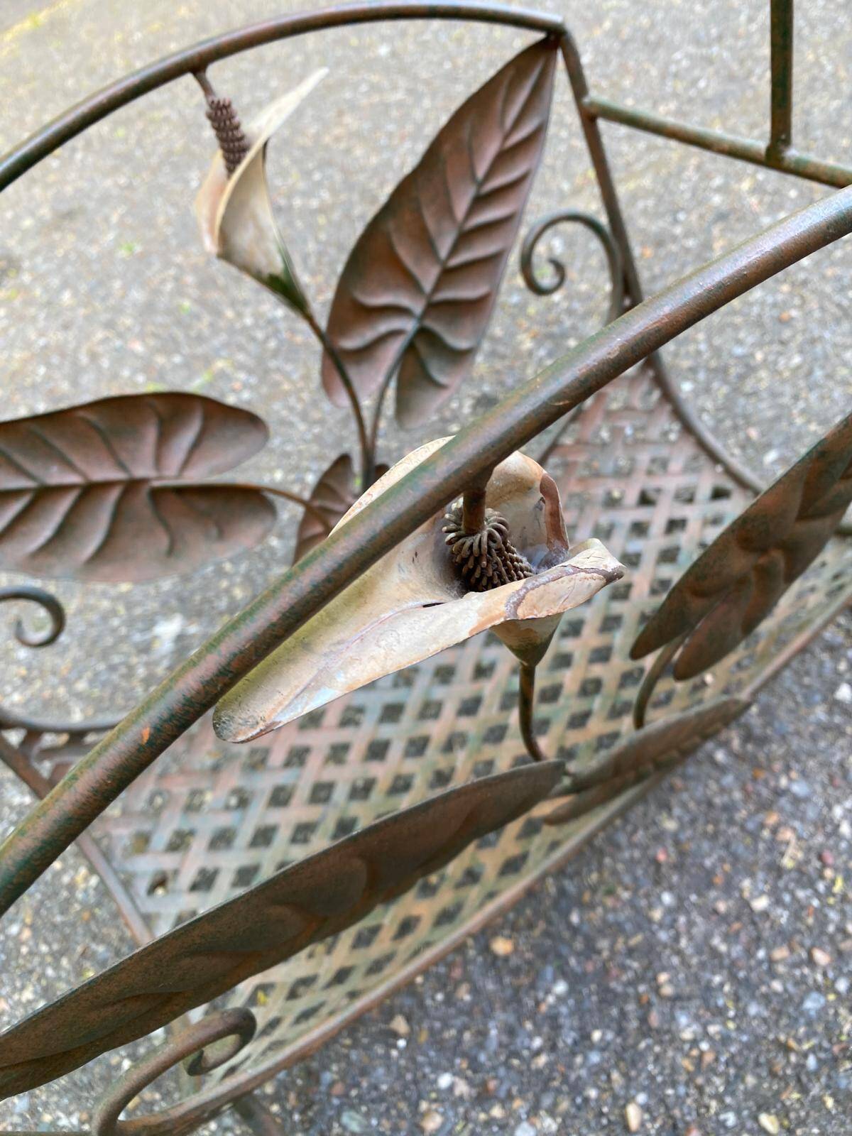 Vintage wrought iron magazine rack with flower pattern.