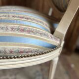 Pair of Louis XVI style chairs in painted wood and satin, classic elegance.