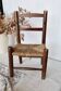 Vintage children's chair in dark wood with woven straw seat