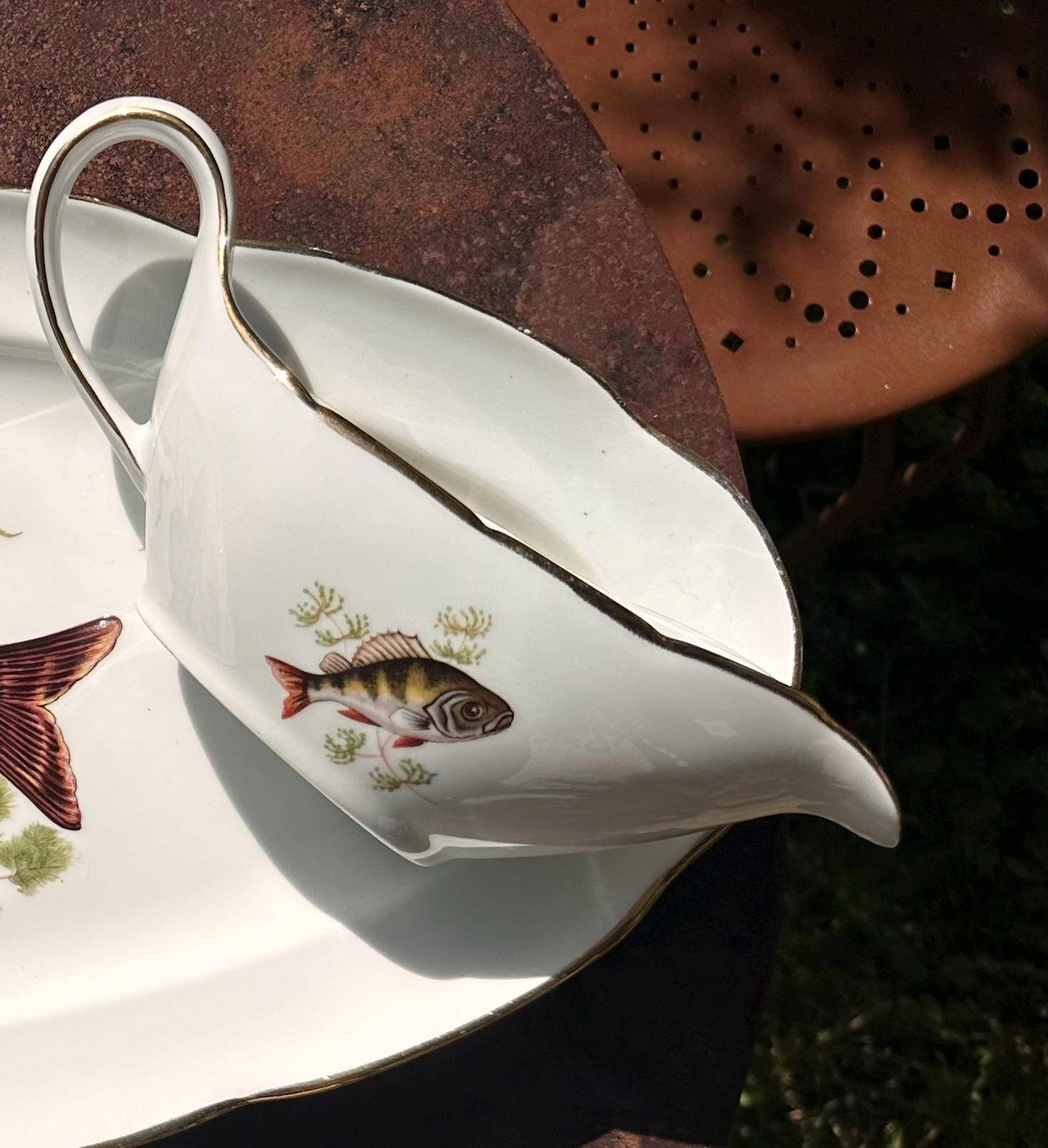 Large fish platter and its vintage porcelain sauce boat, decorated with pike.