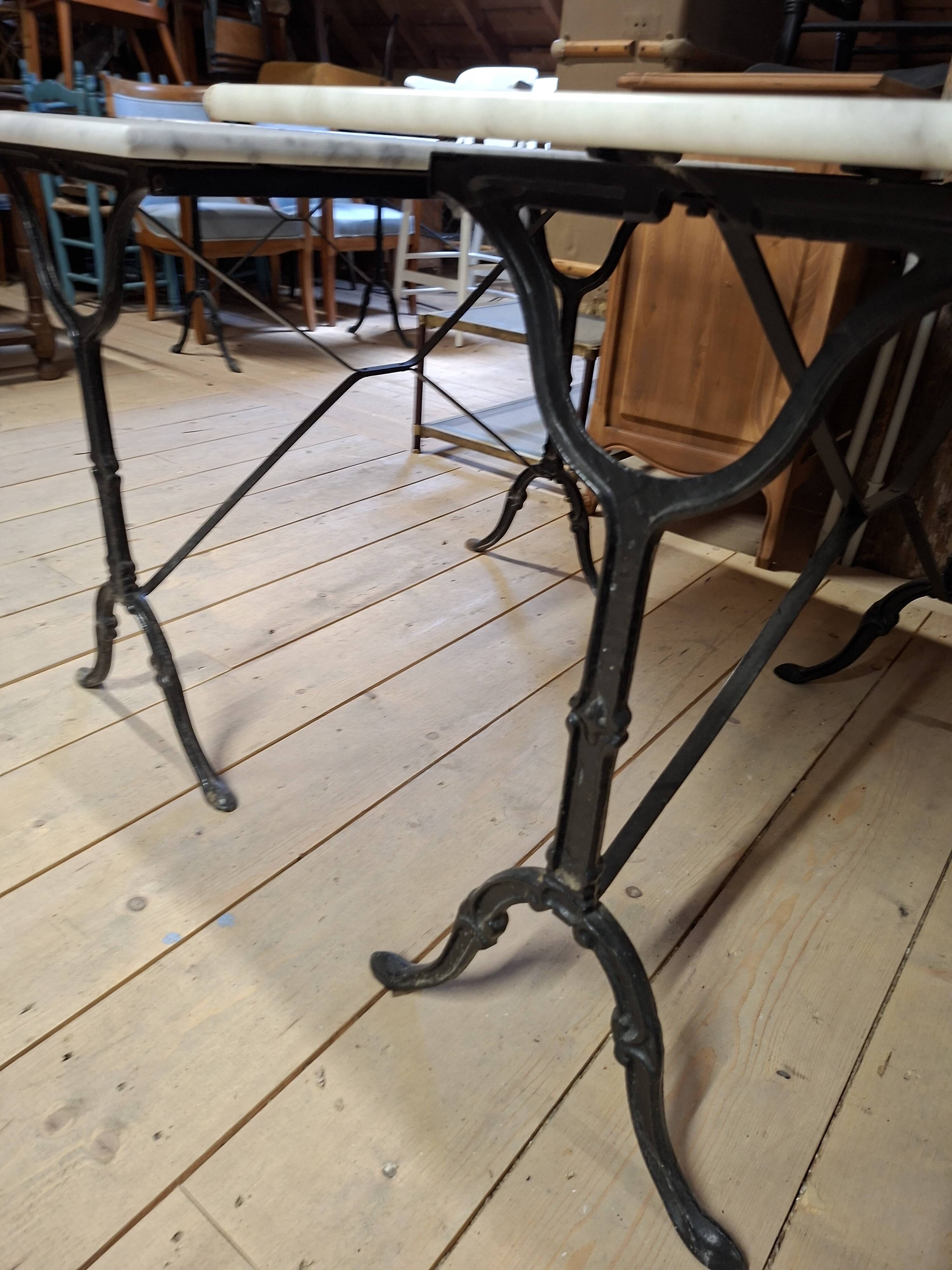 Pair of bistro tables in marble and cast iron.