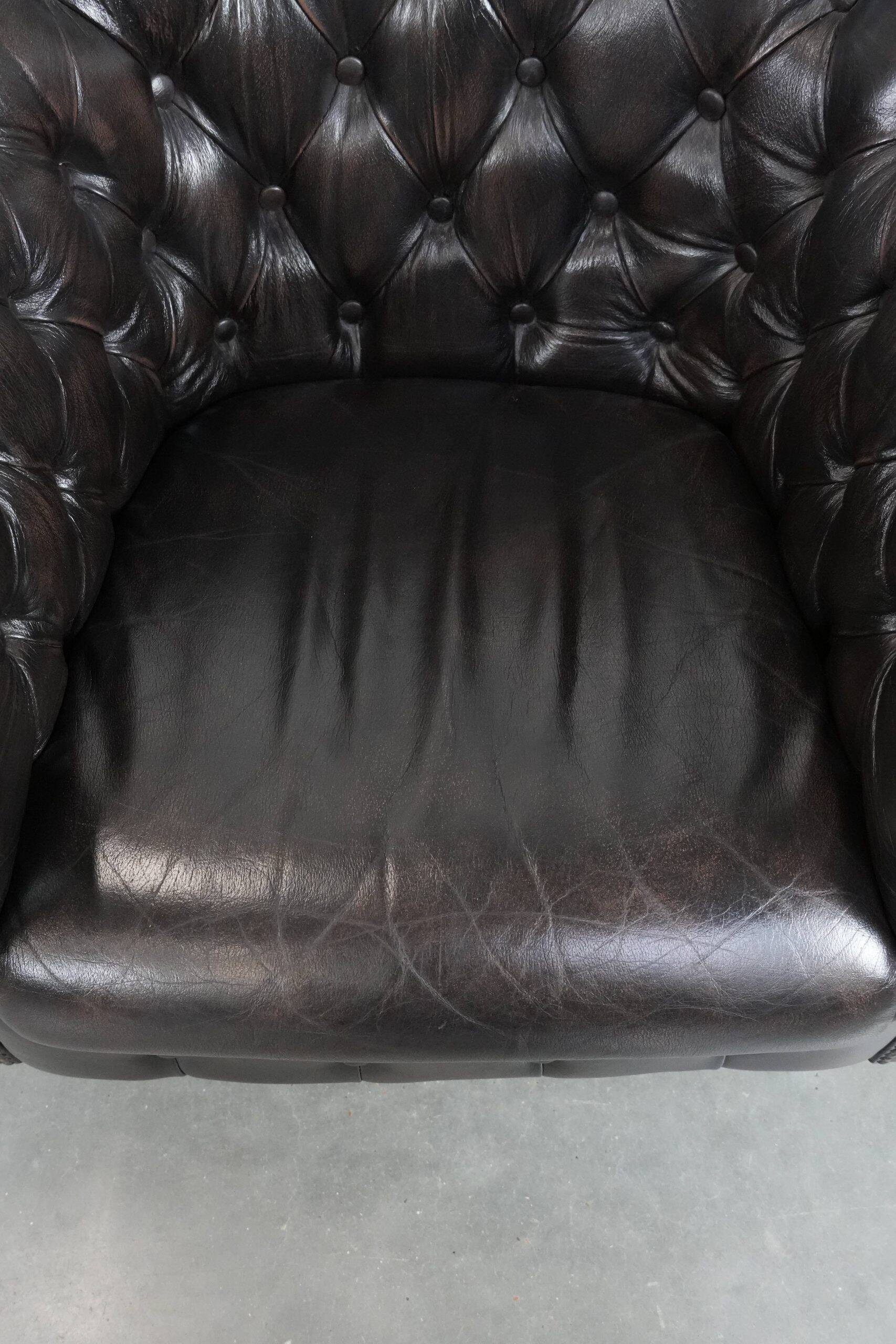 Ensemble de deux luxueux fauteuils club Chesterfield en cuir de vachette noir.