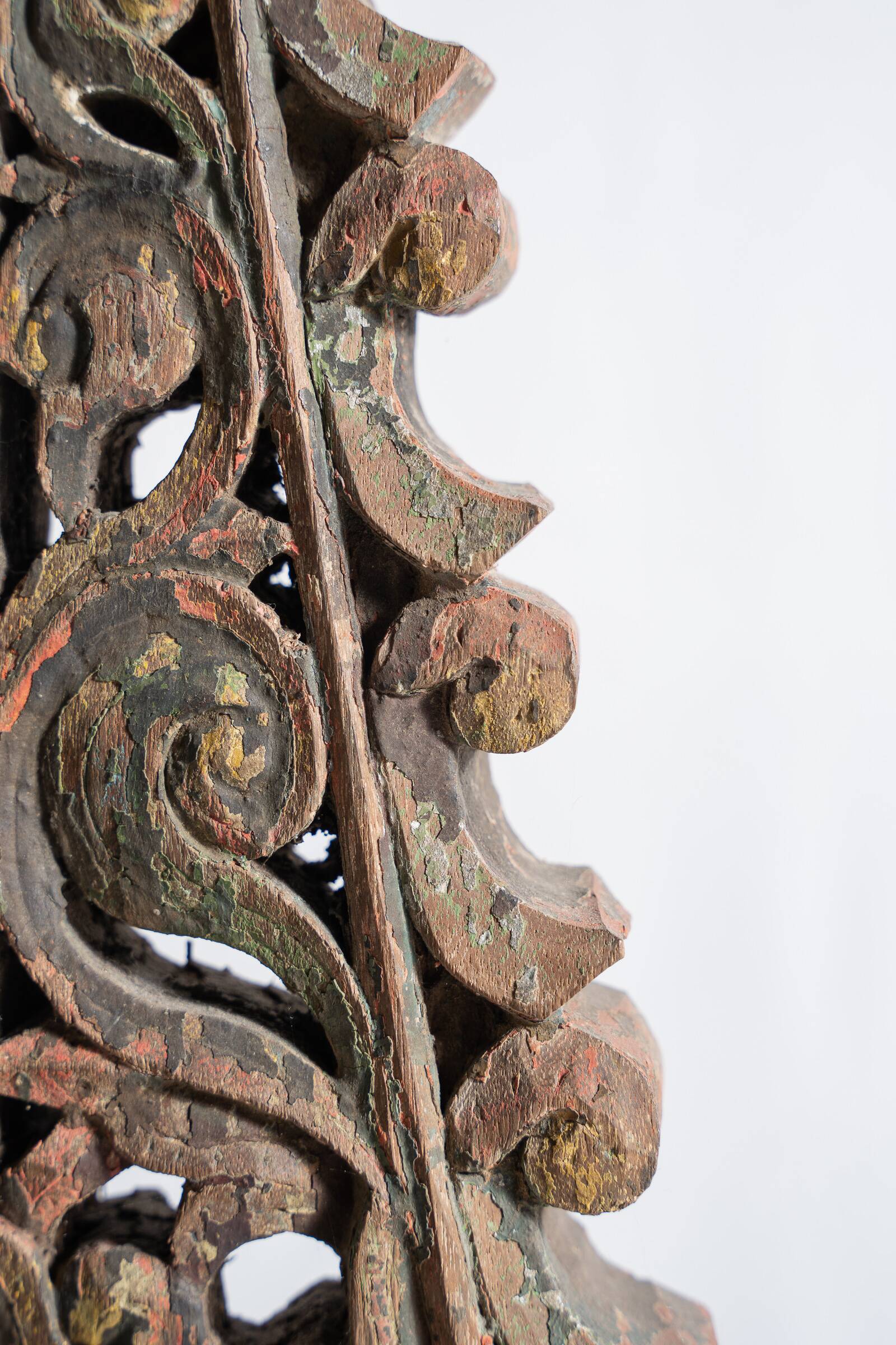 Indonesian construction element in carved wood with intertwined plant motifs mounted on a base (fri