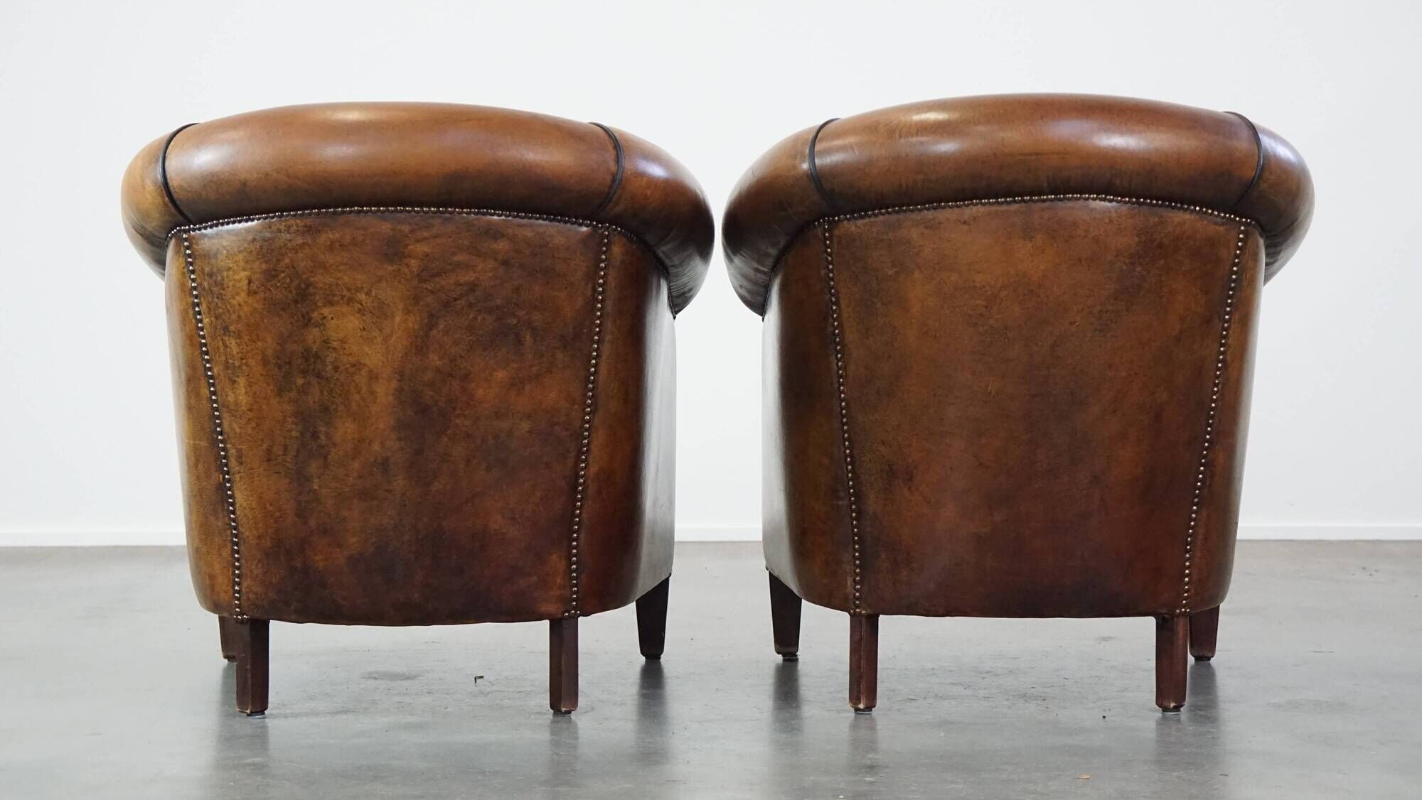 Set of 2 club armchairs in sheepskin leather with black piping