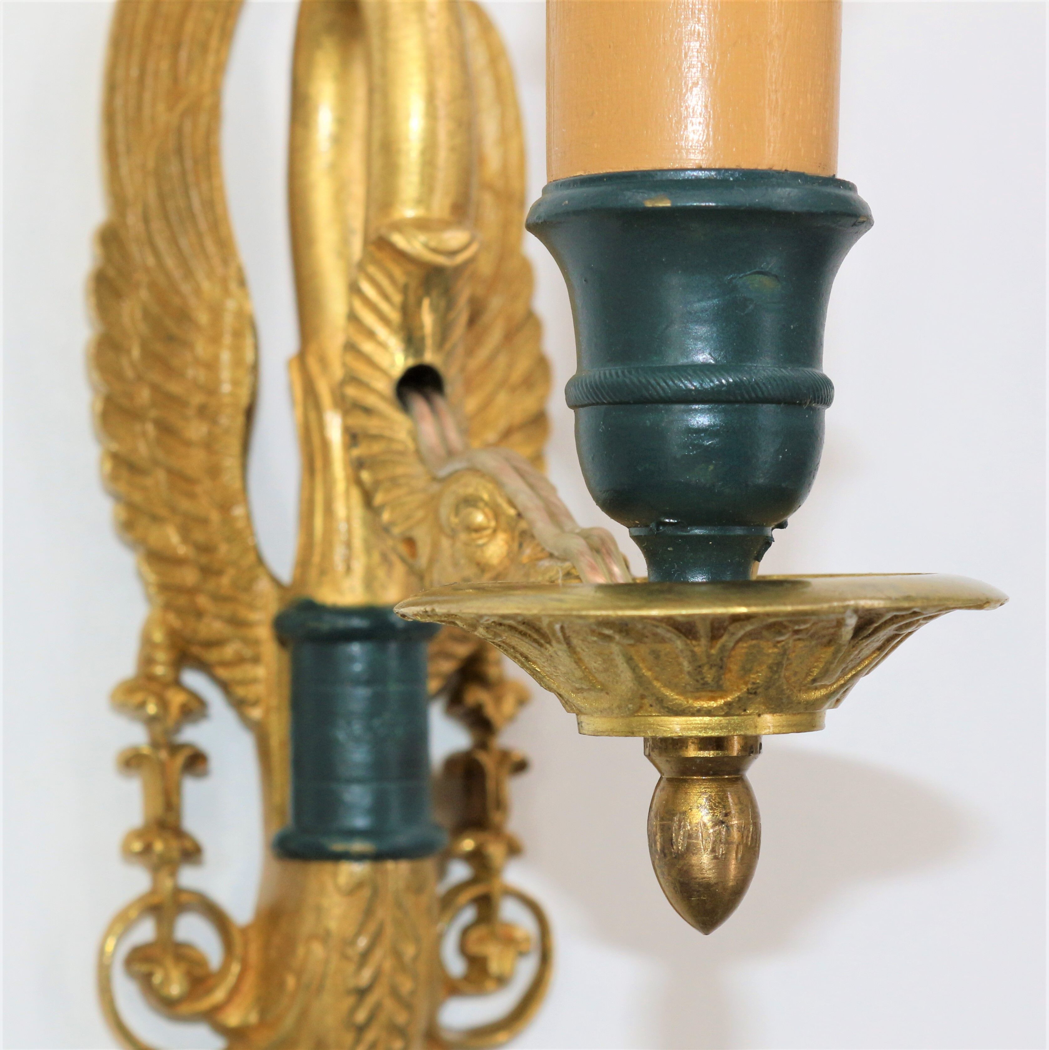 Pair of golden bronze wall lamps in triumphant empire swan style