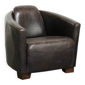 Fauteuil aviateur en cuir de vache dans une palette de couleurs sombres.