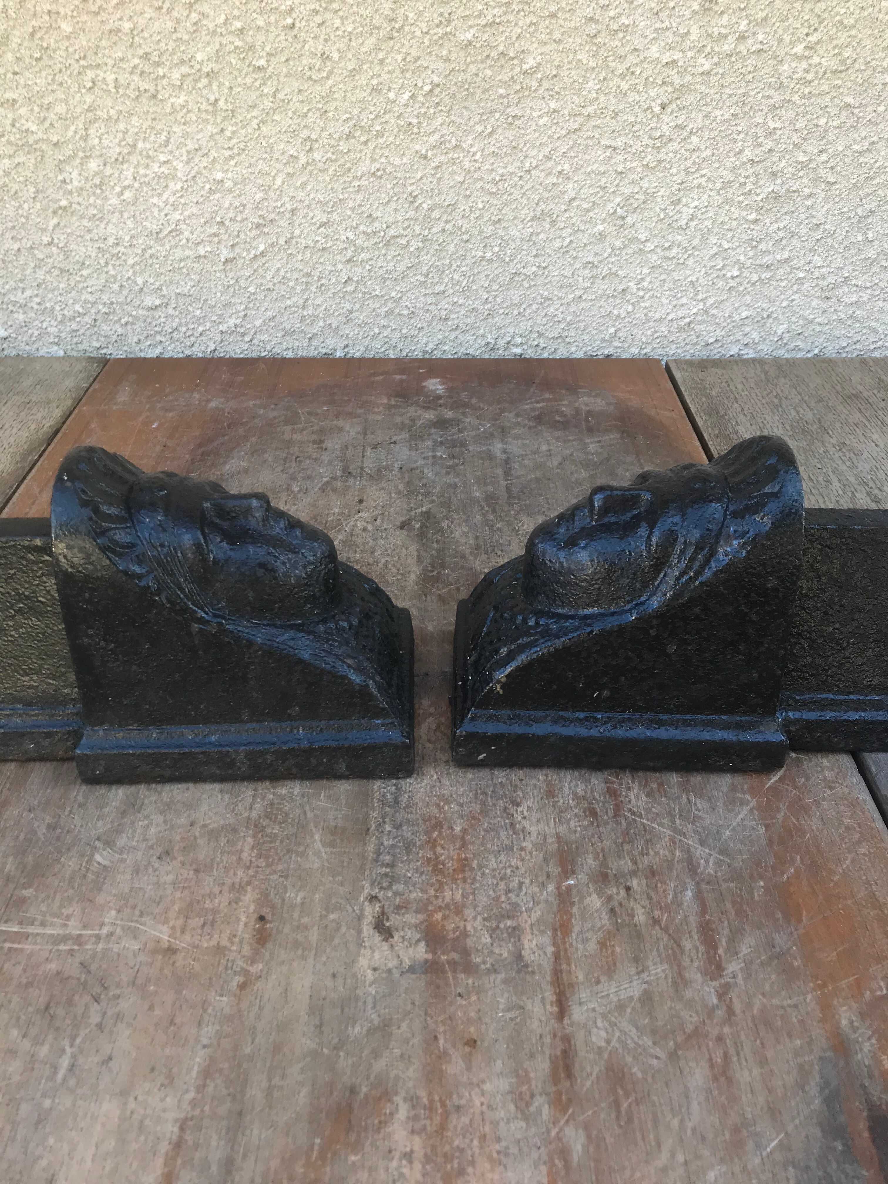 Old pair of chimney caterpillars shape of the head of a woman in iron