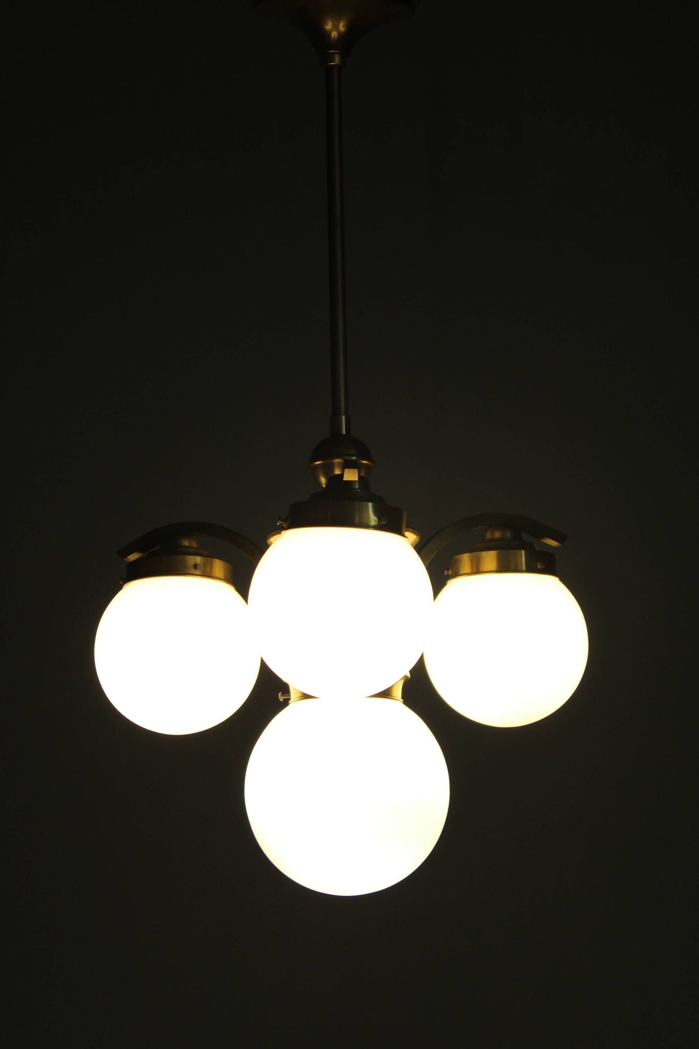1930s Czechoslovak Art Deco brass chandelier with four opaline glass globes