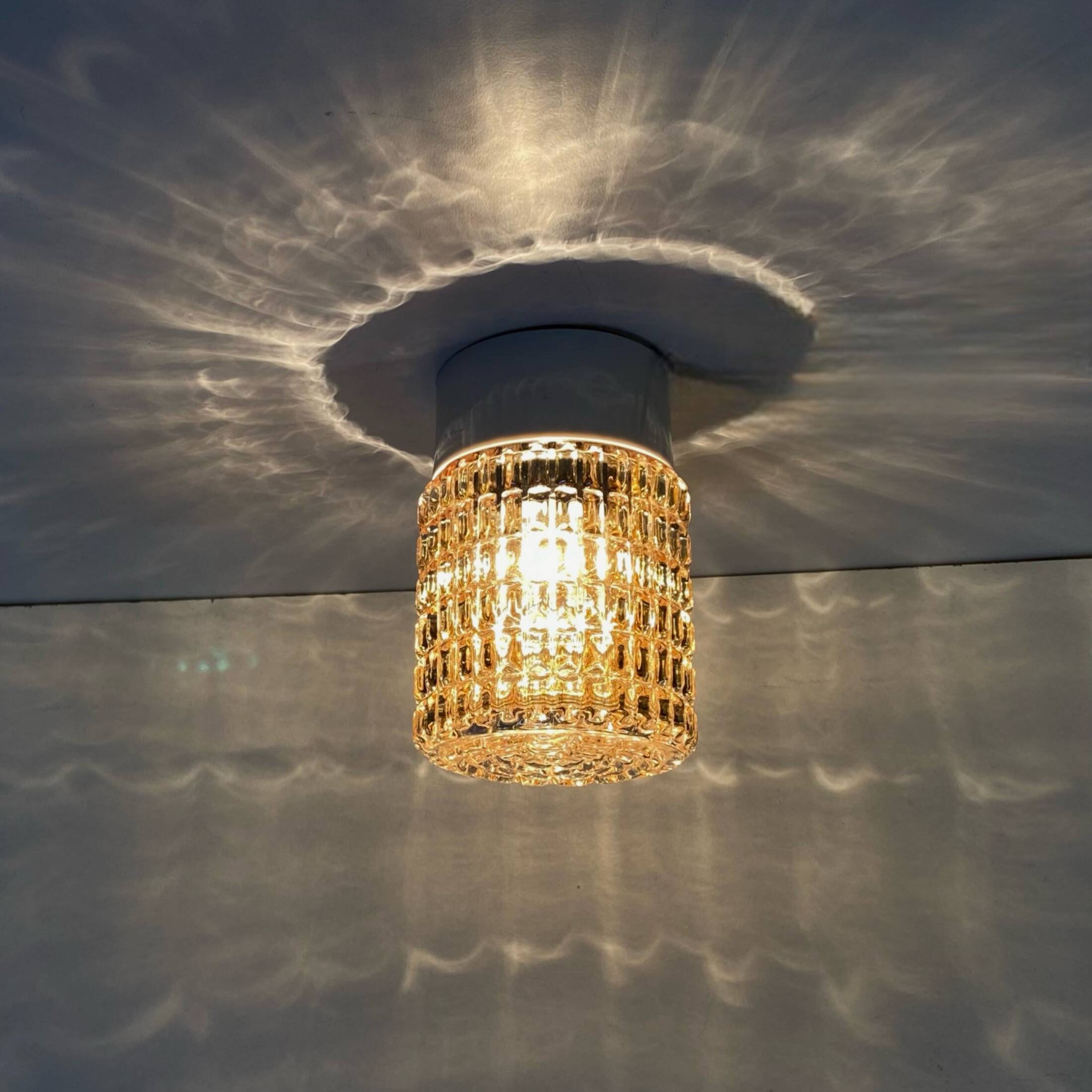 Old wall light in amber glass and plastic fixing base 1970