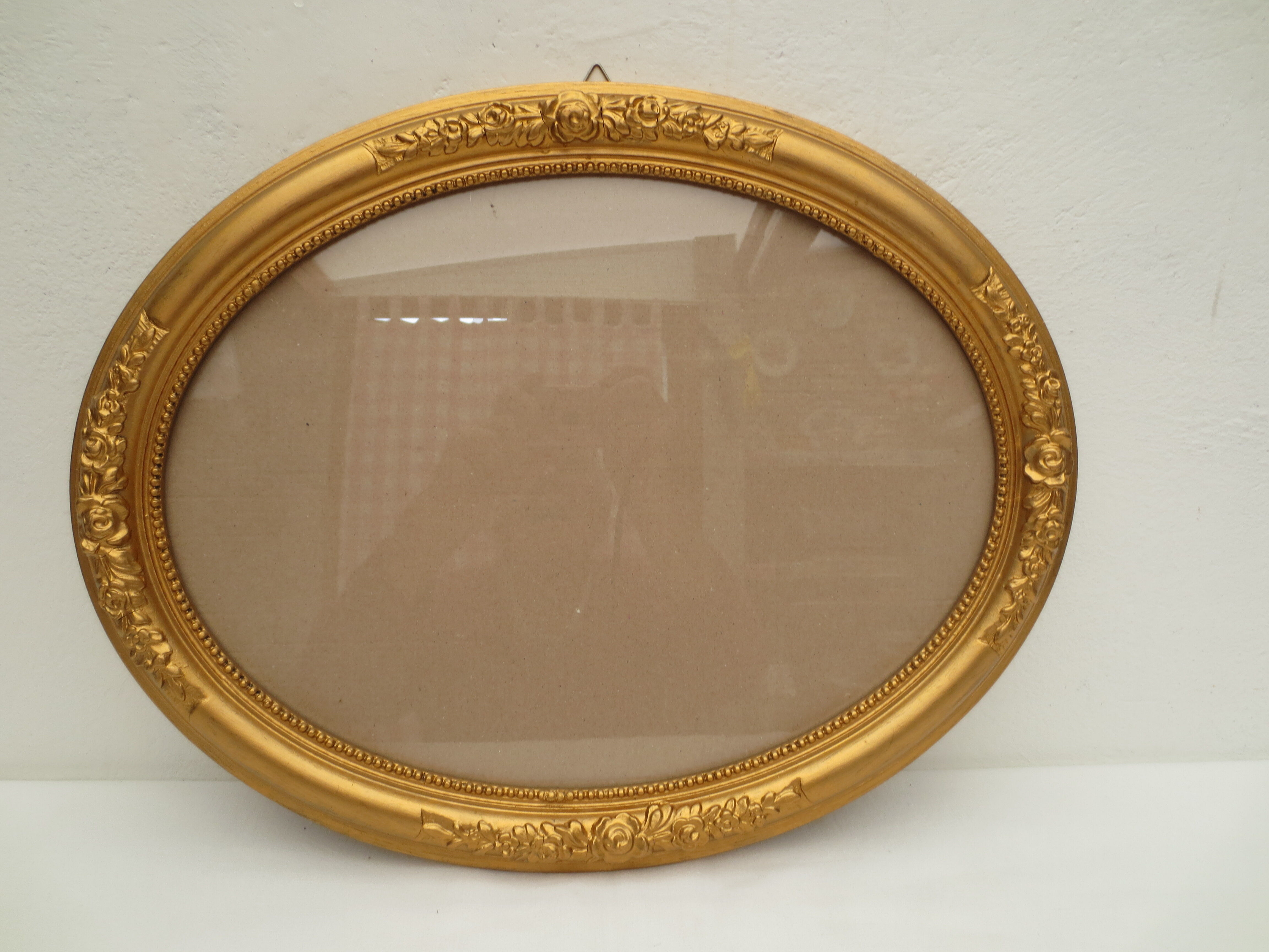 Large old oval gilded wooden frame and stucco decorations