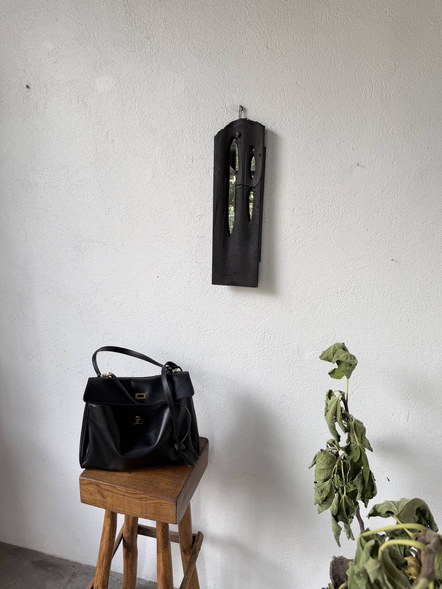 Brutalist hammered mirror, free-form, patinated metal.