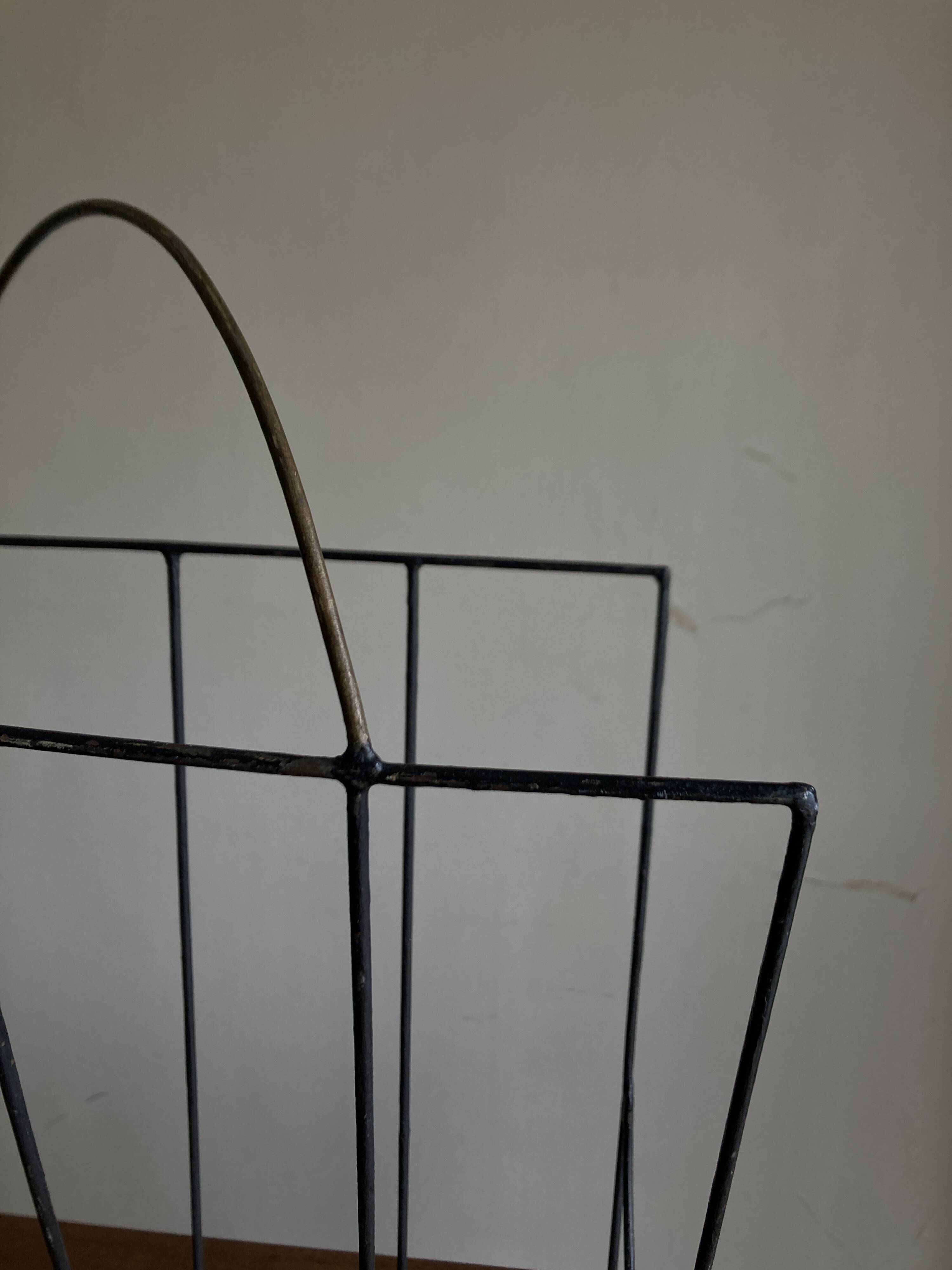 Mid-century poetic magazine rack in black metal
