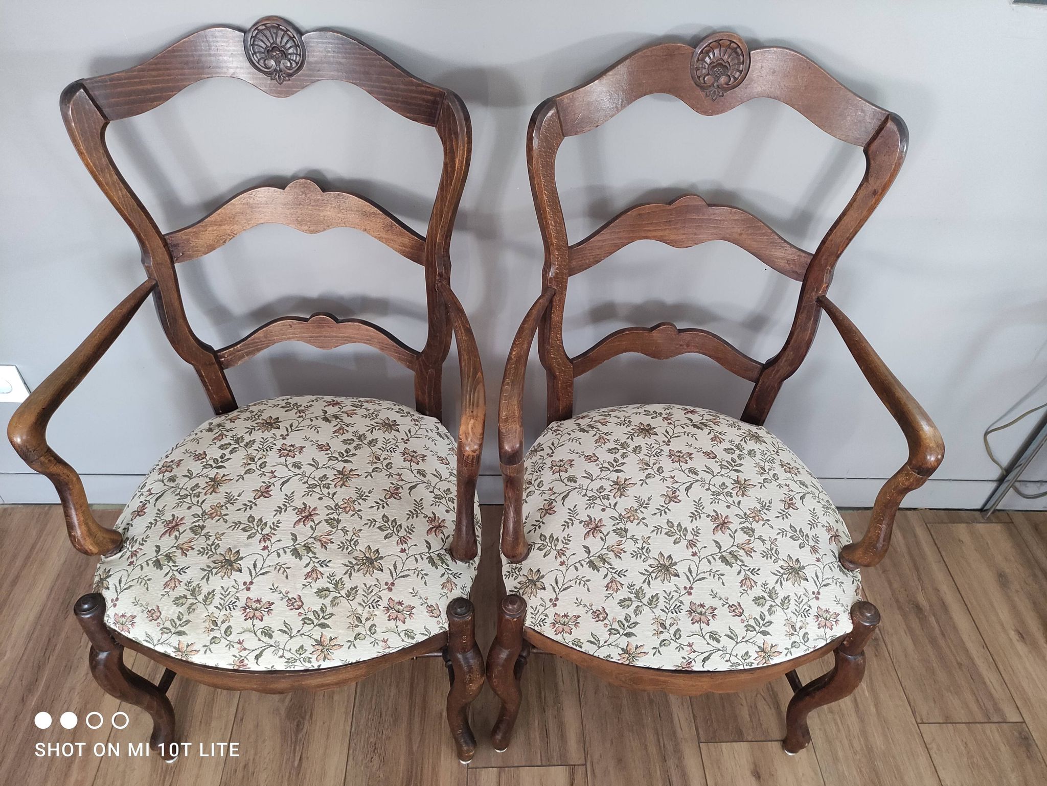Pair of Provençal armchairs in brown wood and floral fabric.