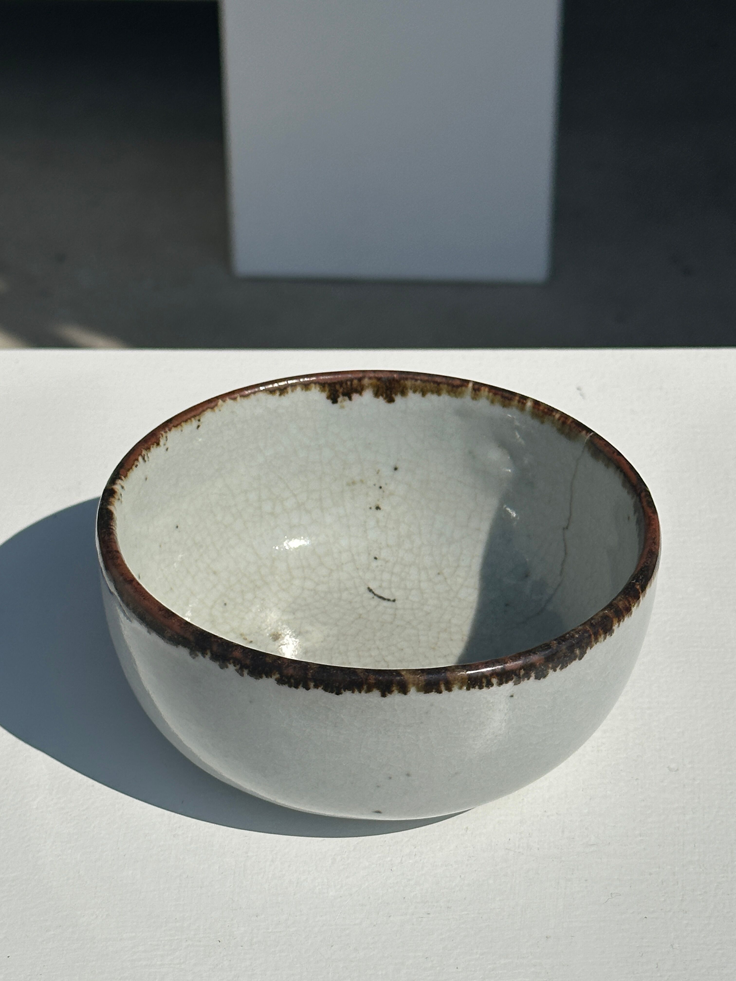 Small white glazed ceramic bowl black edges