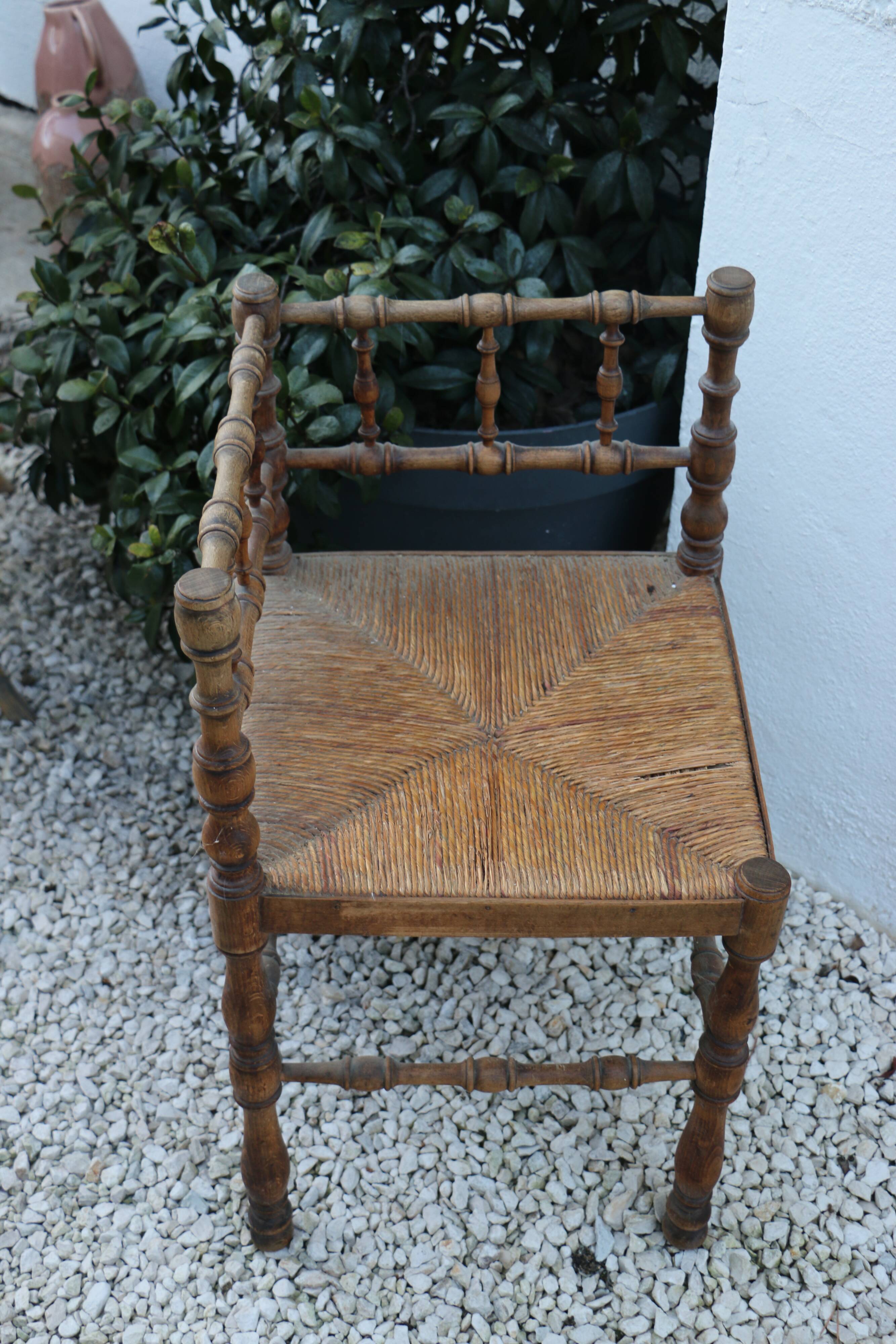 Antique corner chair in wood bamboo style seated in straw