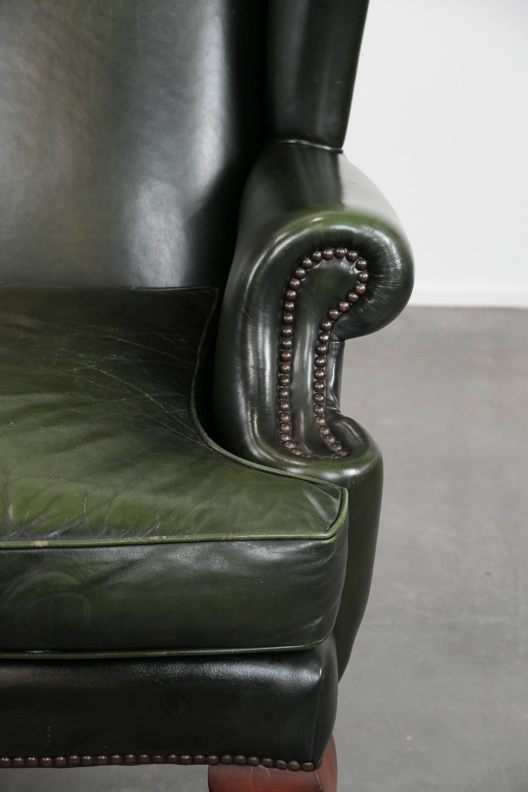Smooth classic cowhide Chesterfield armchair in a stylish dark green color