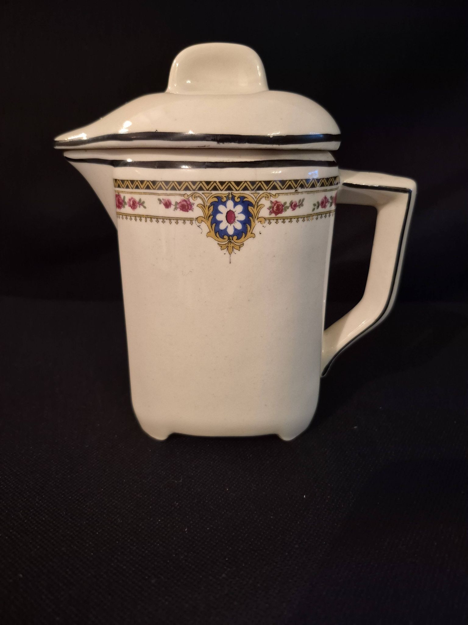 Vintage vase, geometric frieze and flowers with a black border.