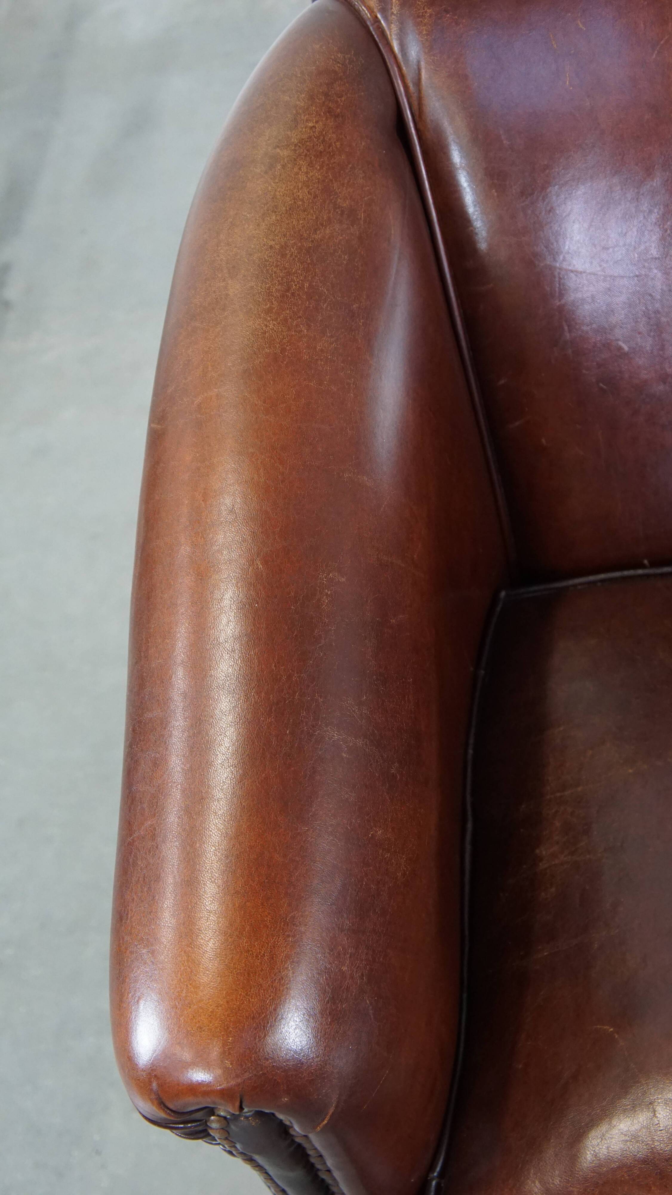 Sheepskin club armchair, correct finishing with decorative nails