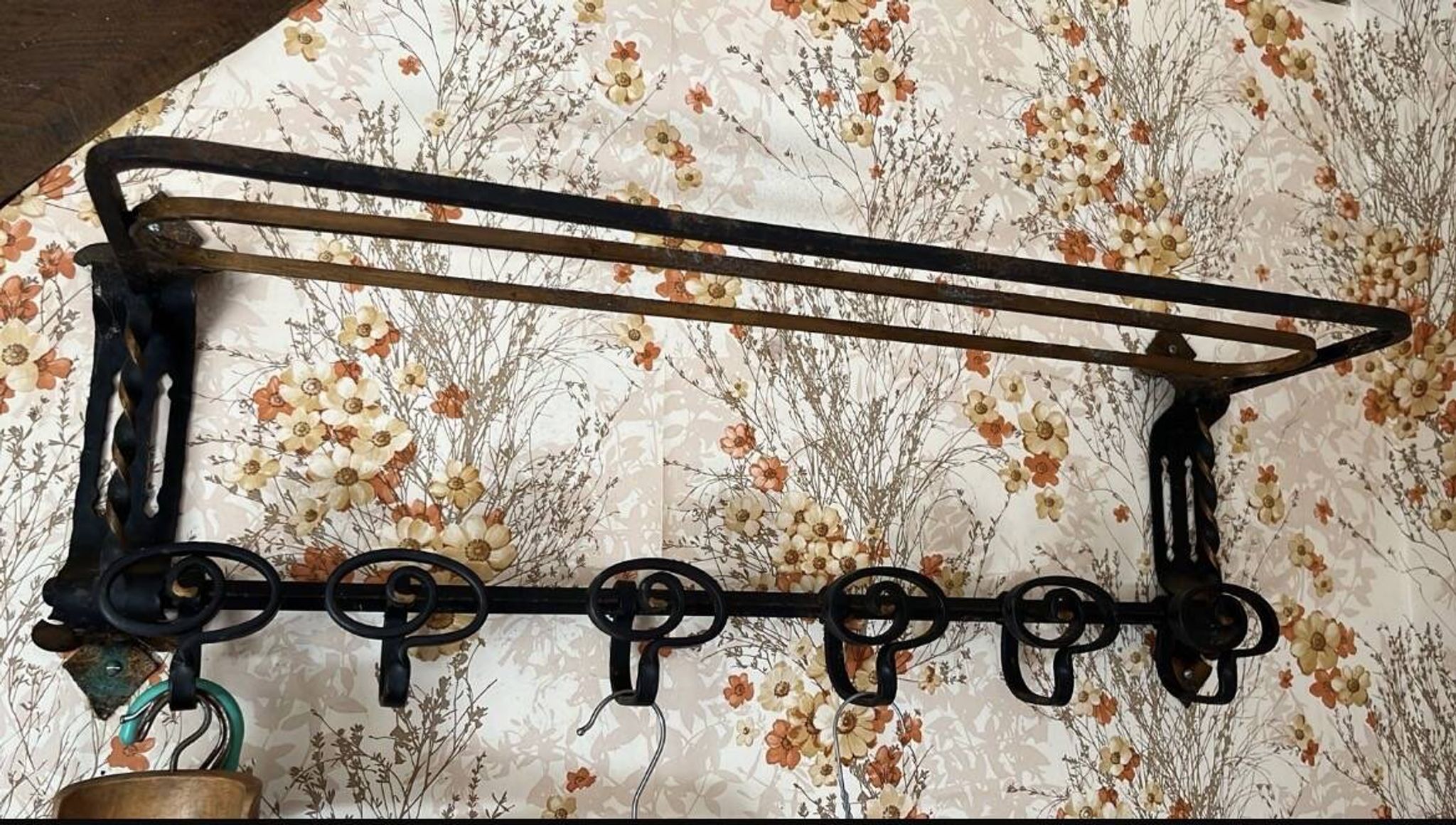 Large antique wall-mounted coat rack in wrought iron.