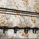 Large antique wall-mounted coat rack in wrought iron.