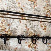 Large antique wall-mounted coat rack in wrought iron.