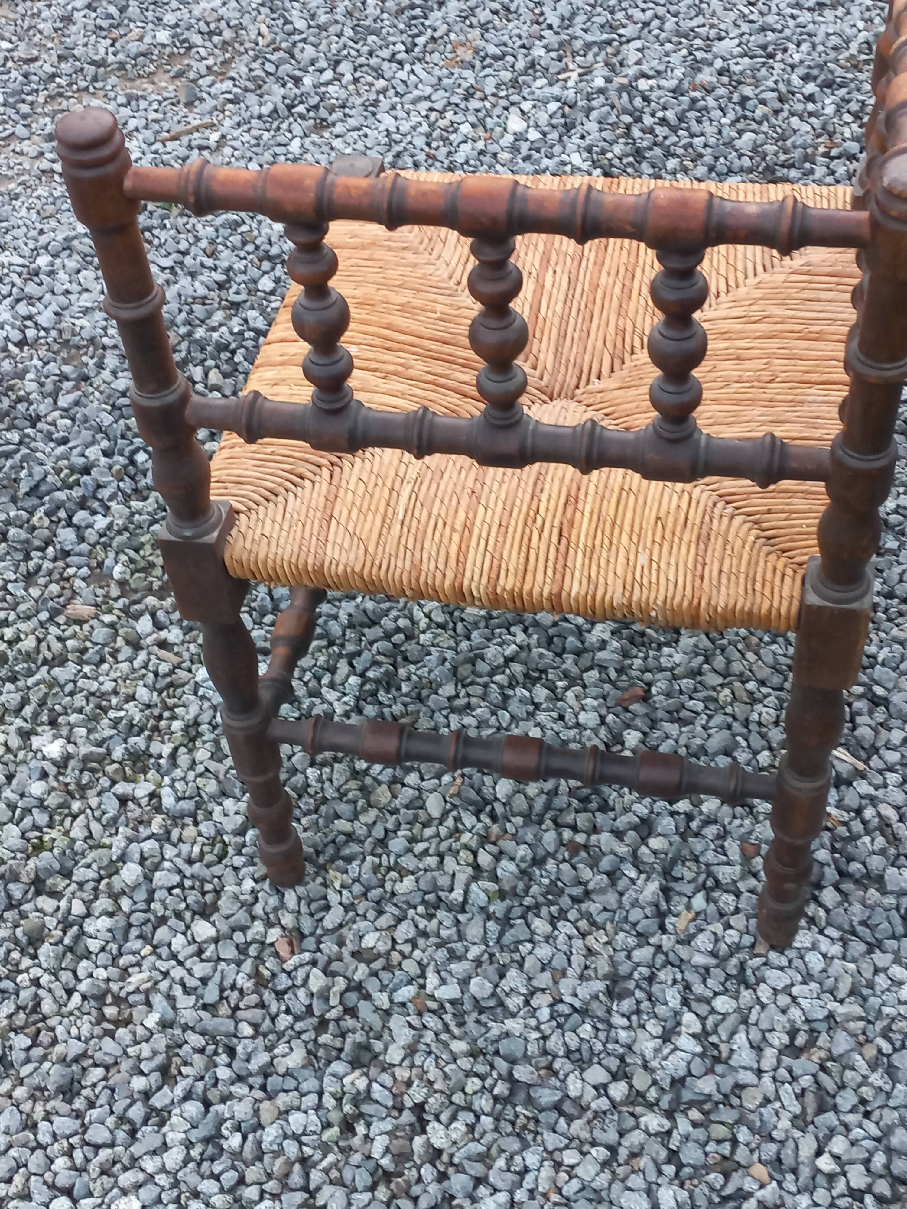Pair of angled armchairs with turned wood and rush seats from the 1960s.