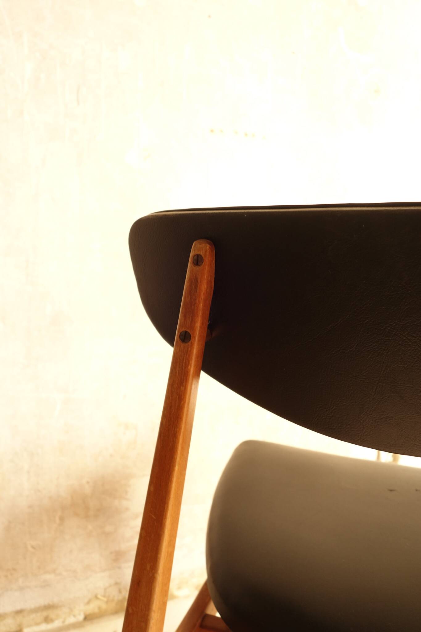 Pair of modernist Scandinavian chairs in teak and black faux leather.
