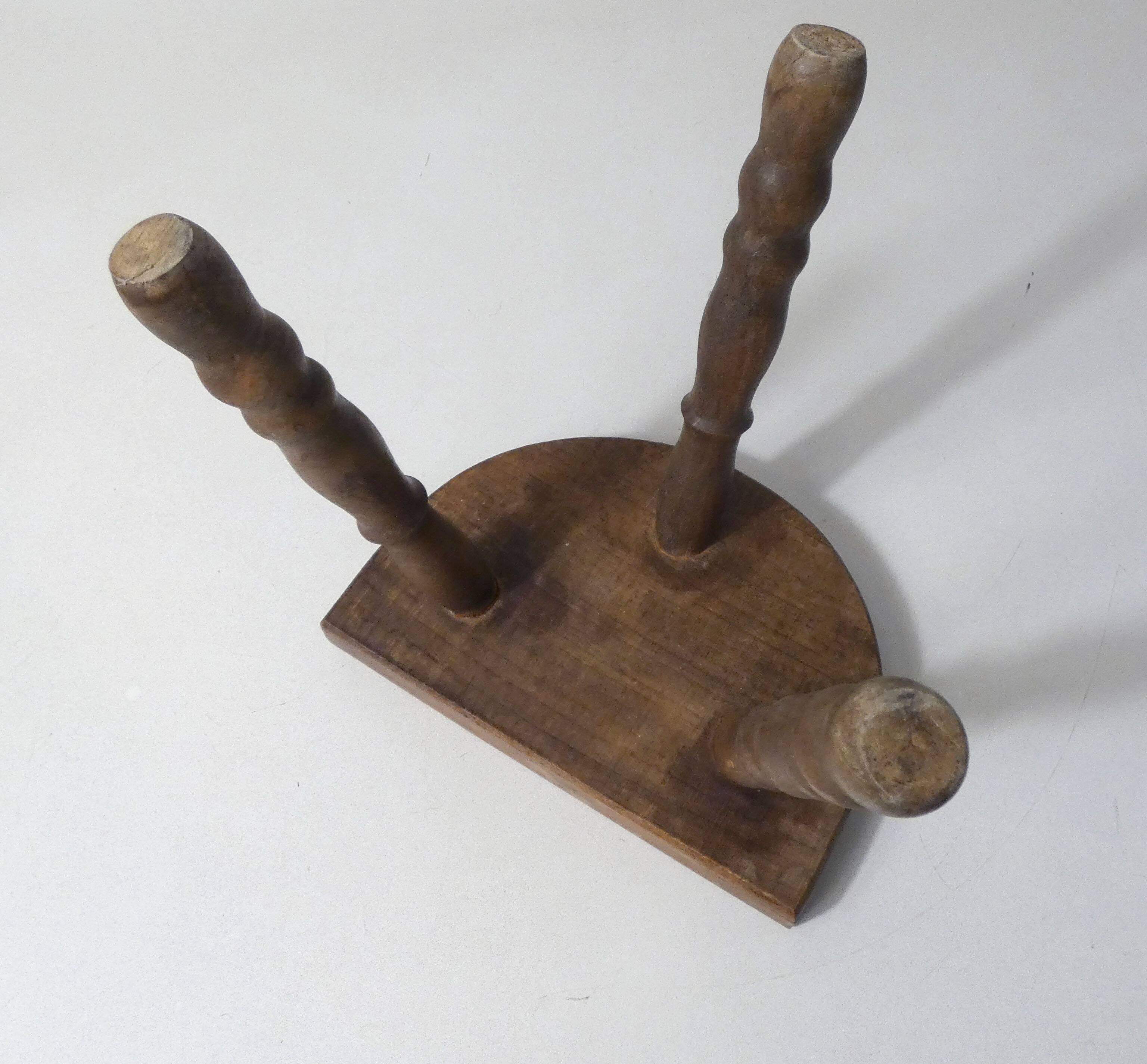 Old milking bench tripod stool in solid wood