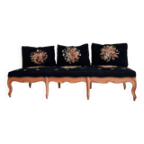 Old bench upholstered in black canvas flowers