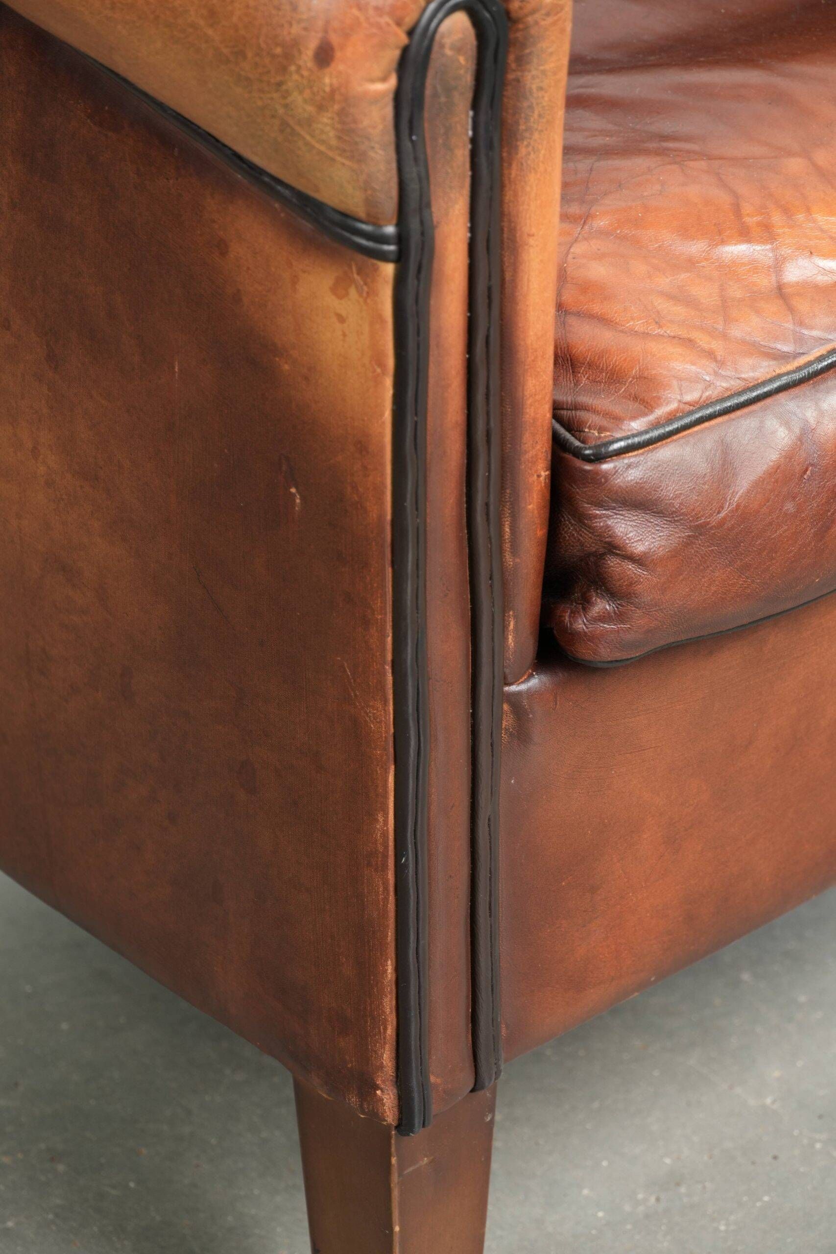 Vintage sheepskin club armchair finished with black piping