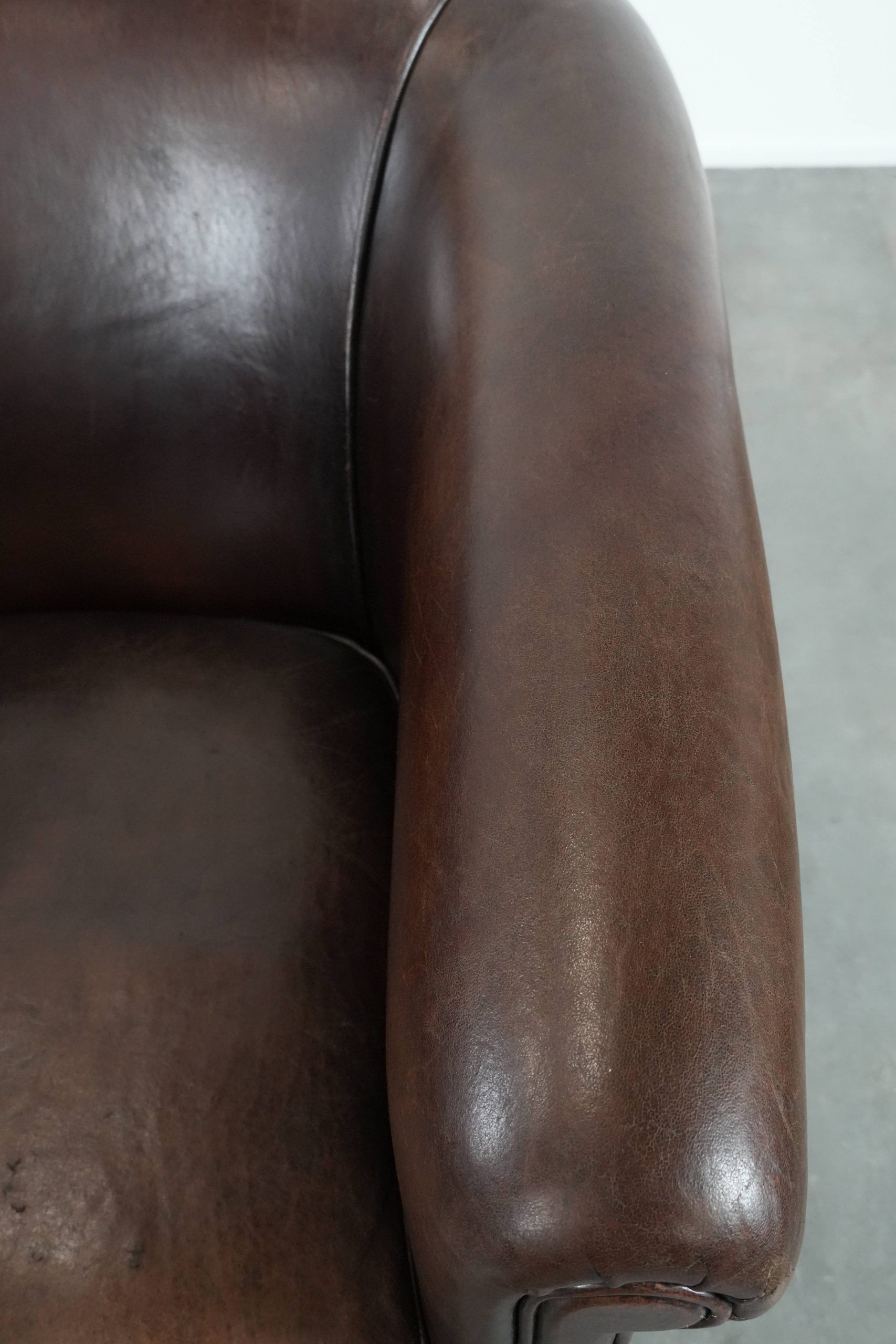 Stylish and sturdy dark brown club armchair made of sheepskin leather