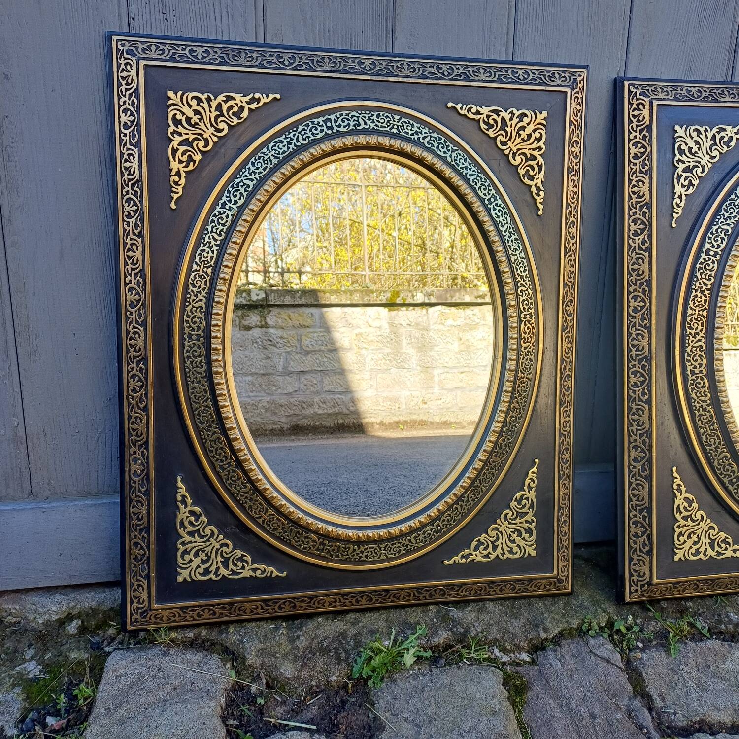 Pair of antique mirrors from the Napoléon III period, black and gilded.