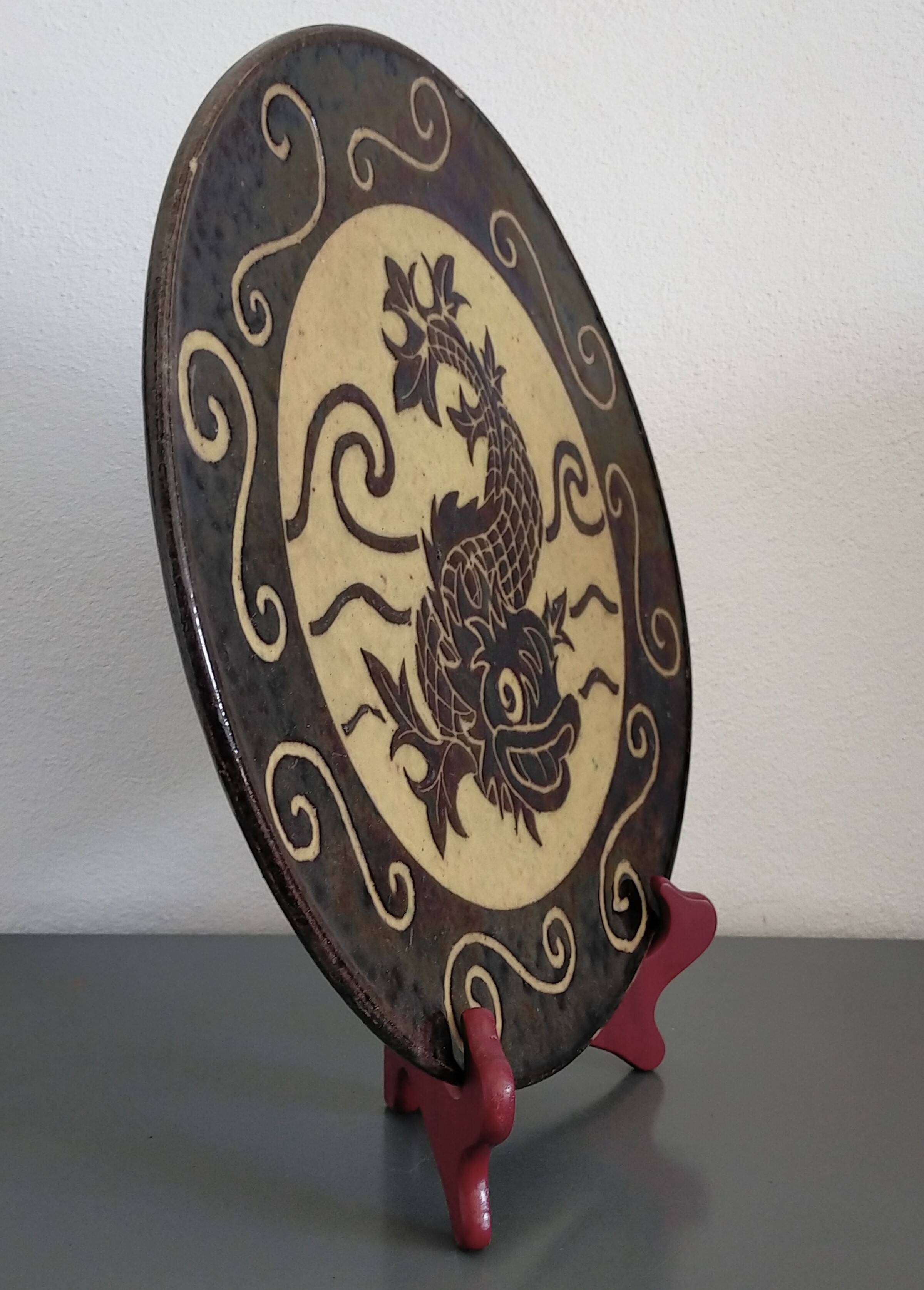 Dauphinois plate in glazed terracotta from around 1950 with dolphin decoration.