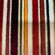 Art Deco armchair in multicolored striped fabric and its footrest