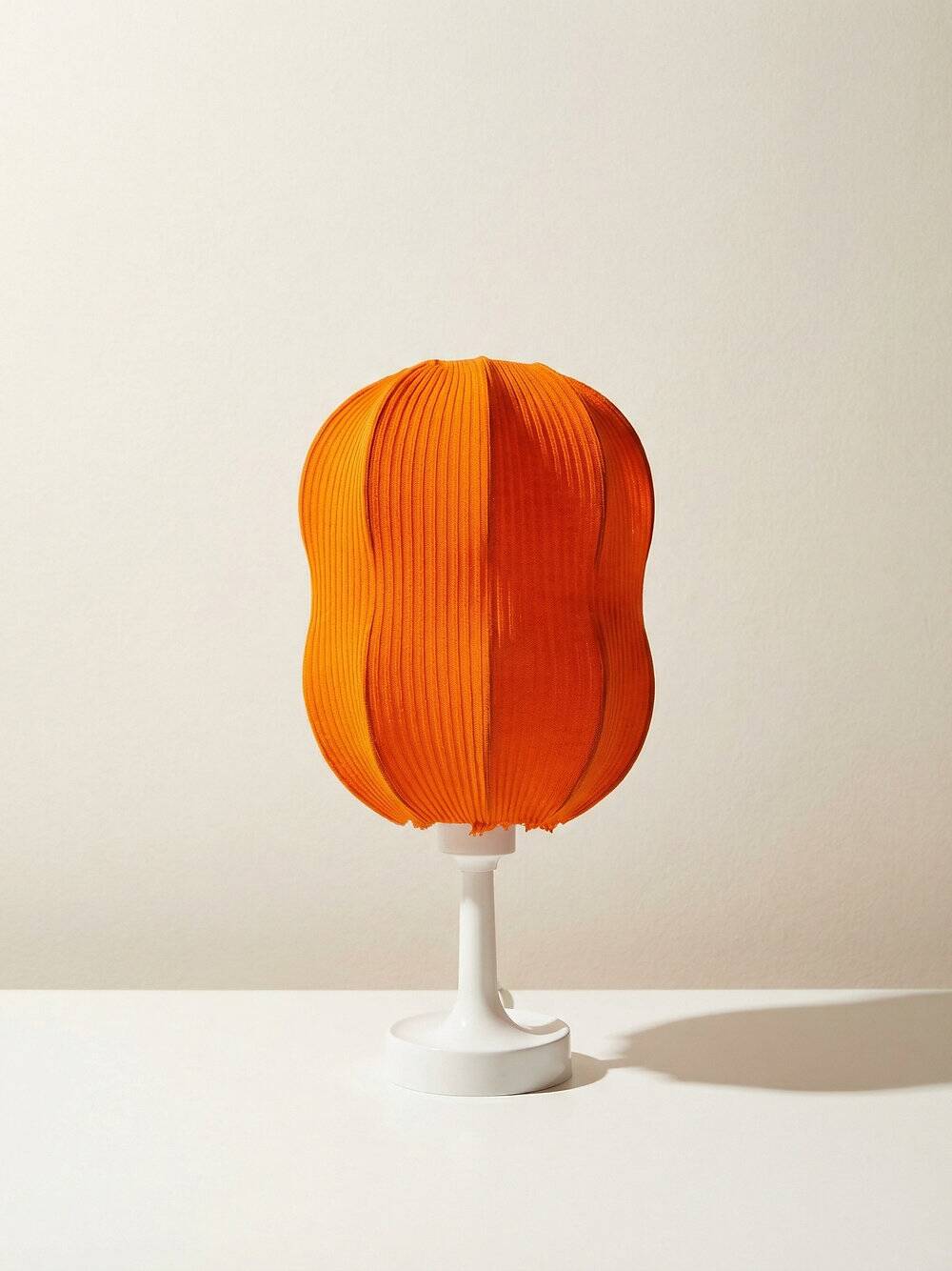 Lamp with a plastic base and a coloured fabric shade in Mid Century style.