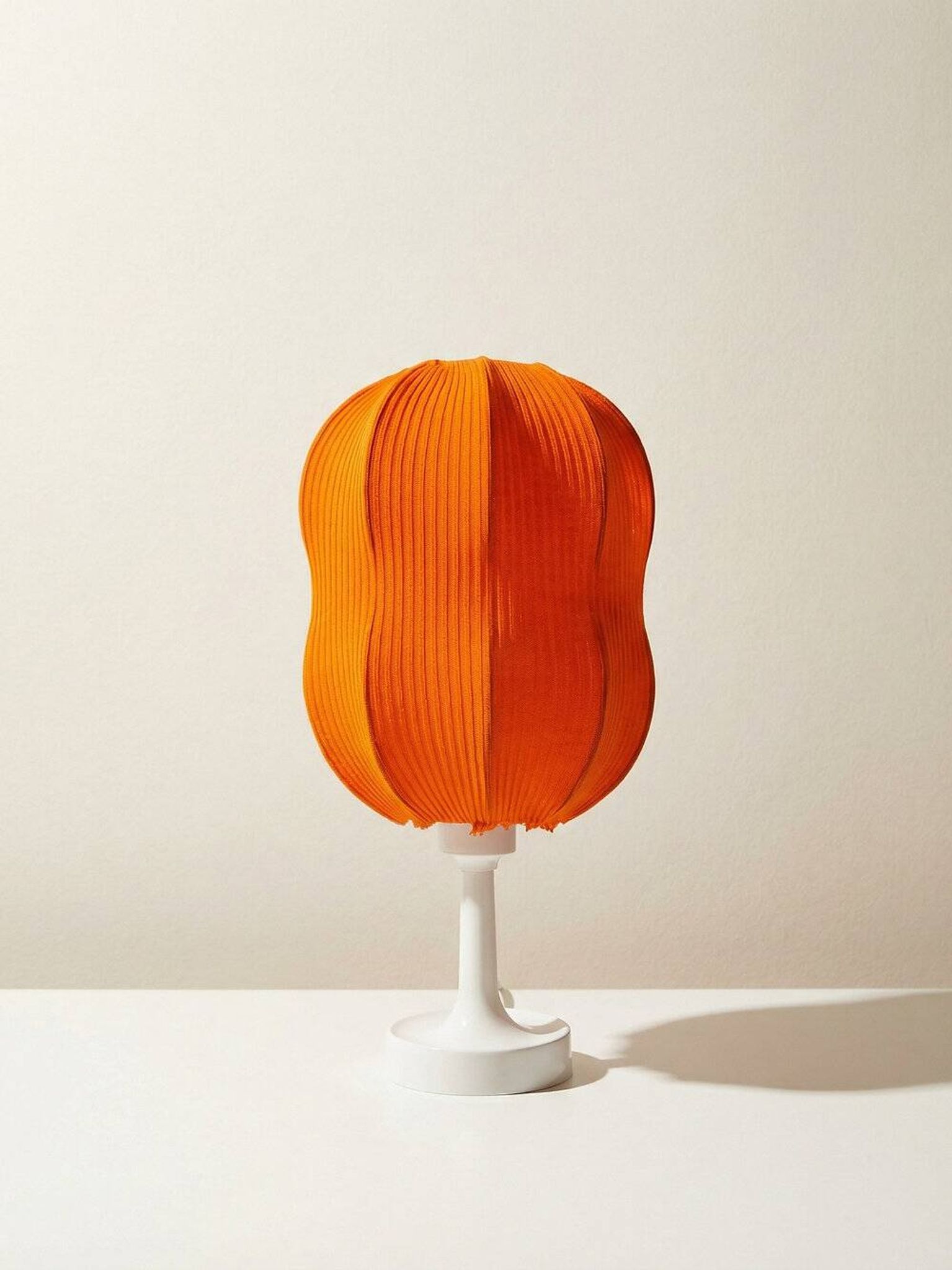 Lamp with a plastic base and a coloured fabric shade in Mid Century style.