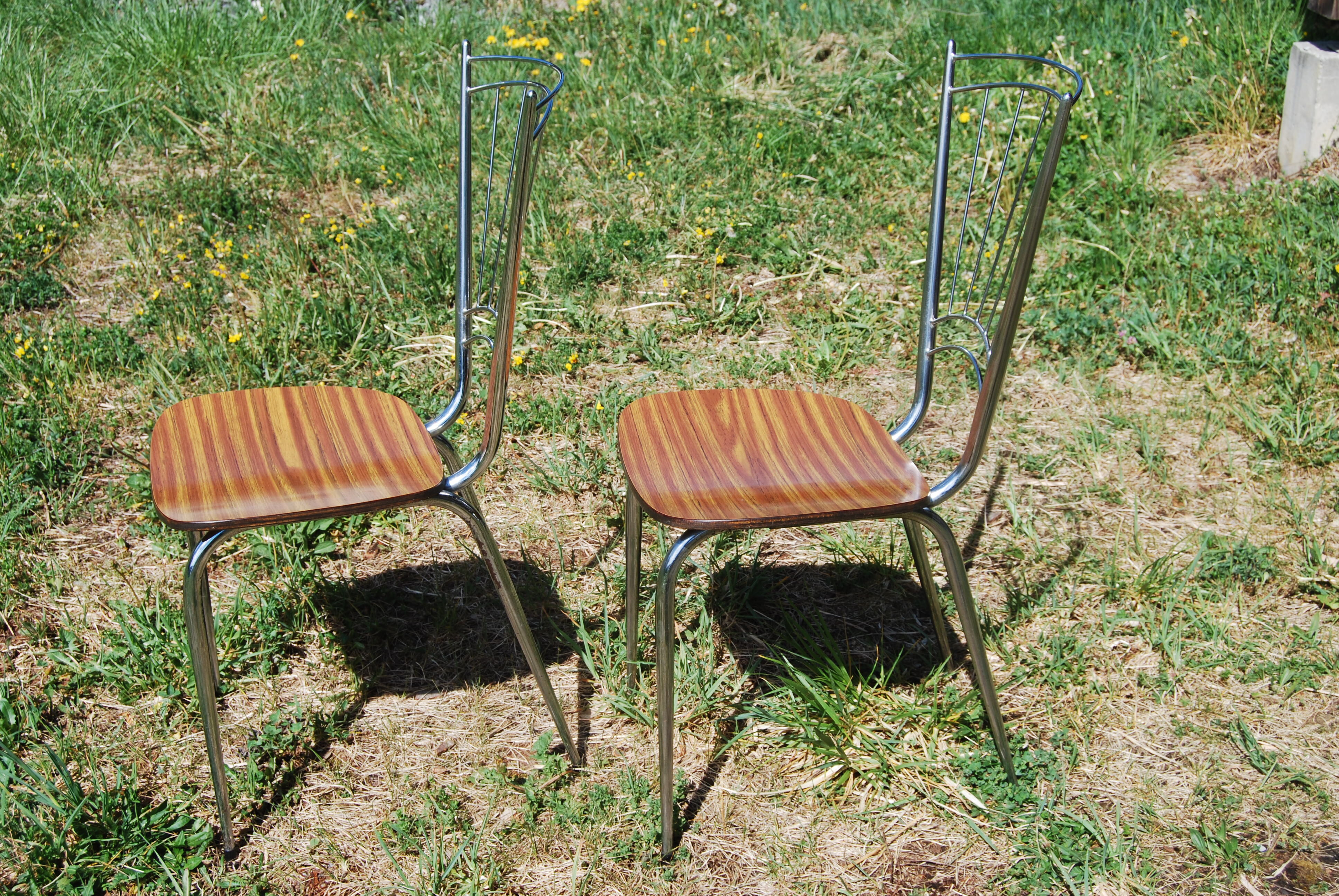 Pair of formica chairs with chrome metal backs in the shape of a lyre.