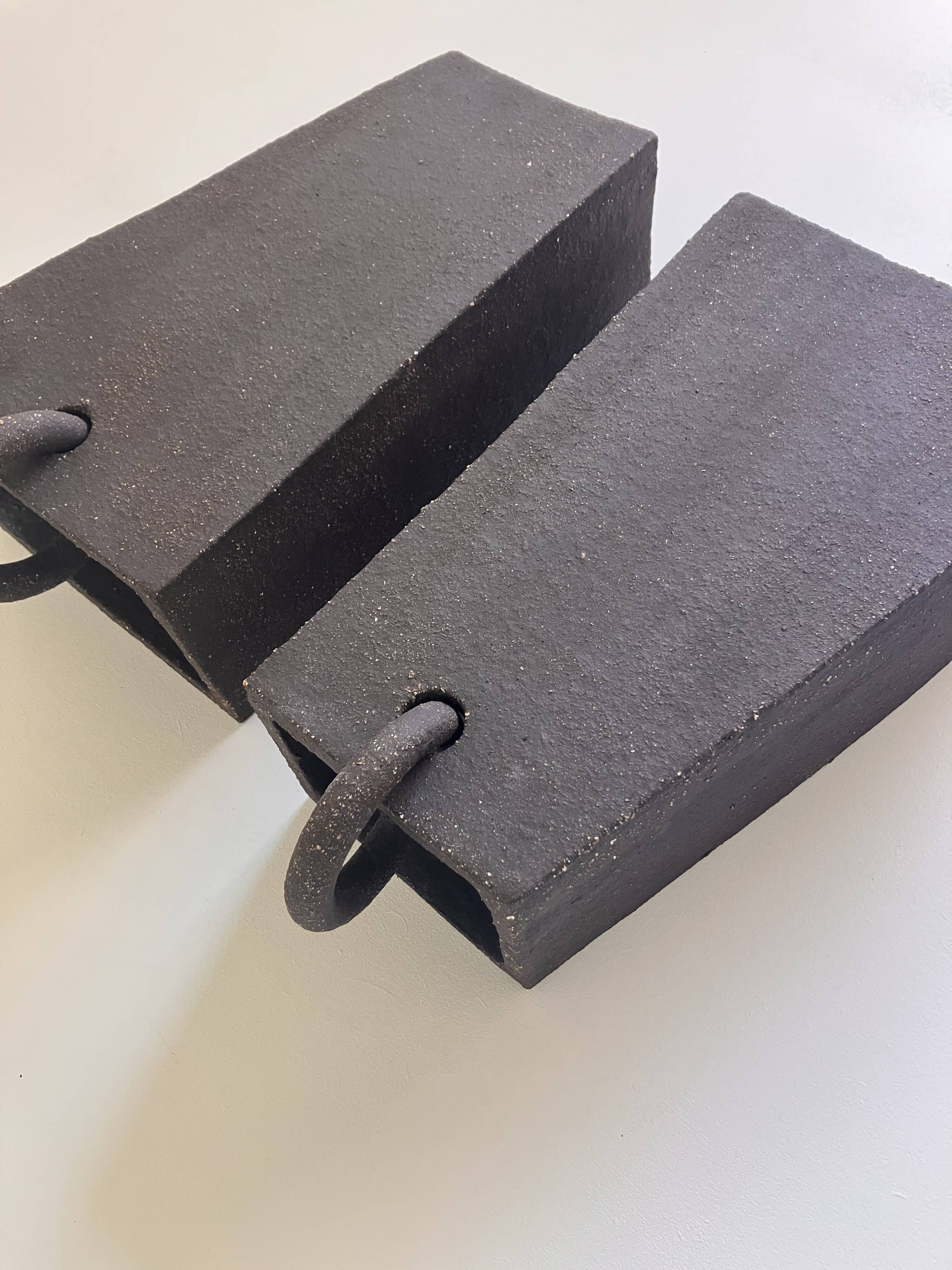Pair of black stoneware graphic wall lights with handmade ring.