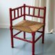 Red turned wood corner chair with rush seating