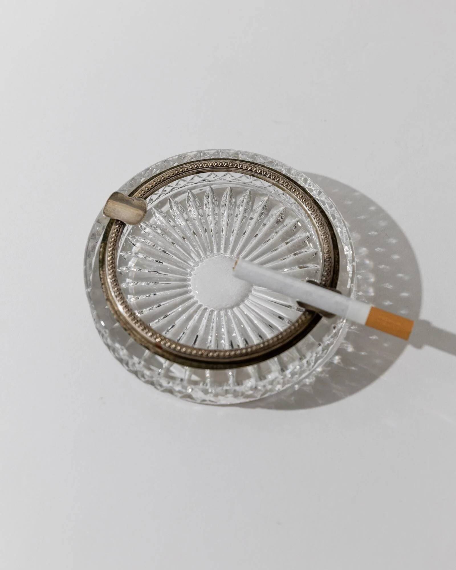 Vintage crystal glass ashtray from the 1920s, silver-edged with a textured pattern, Art Deco table decoration.