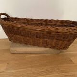 Vintage brown wicker baguette basket, elongated shape, with integrated handles.