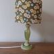 Table lamp with light green onyx base, fabric shade with a khaki background.